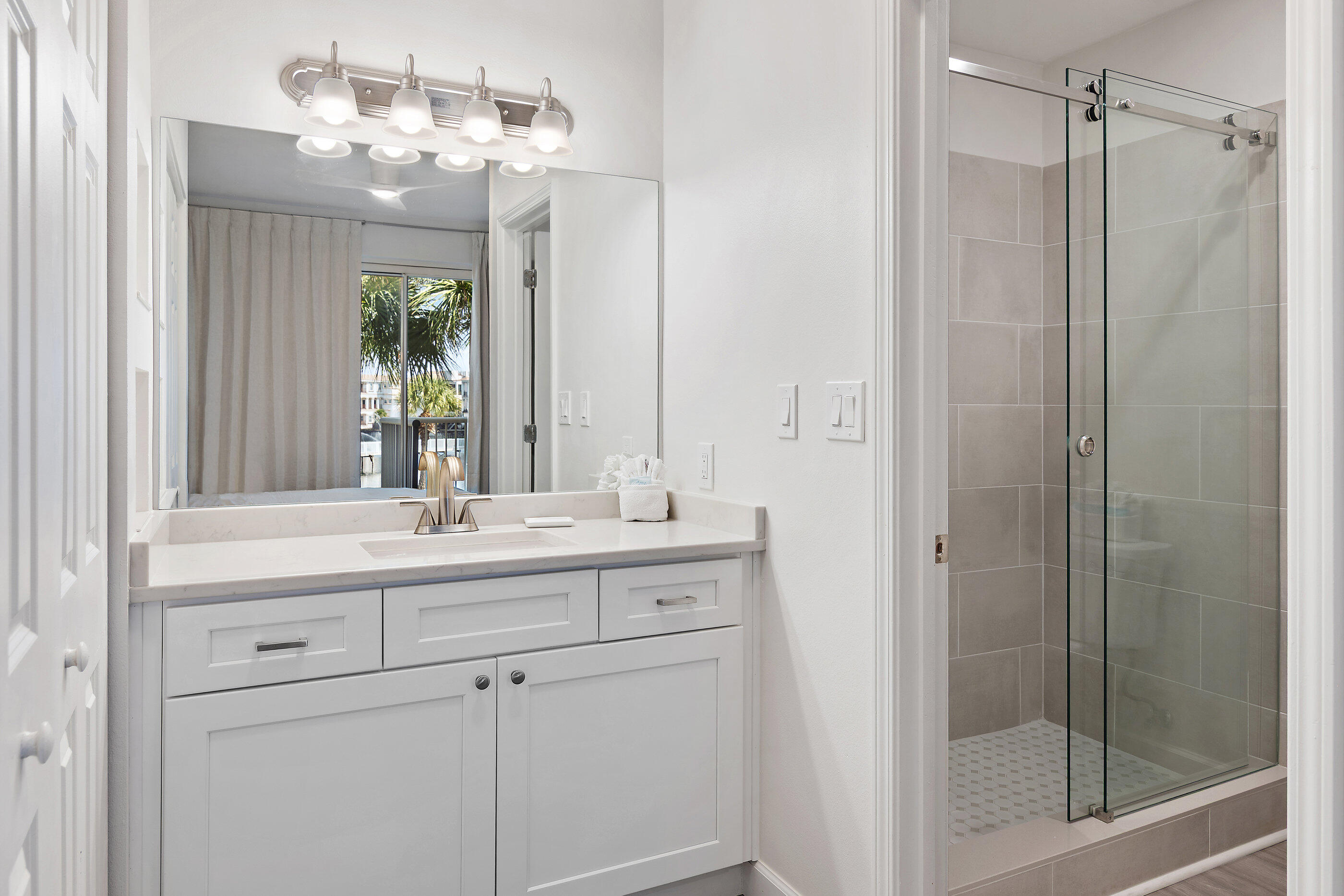 970 Highway 98, Unit 107 Destin, FL 32541 - Photo 19 of 28 a bathroom with a double vanity sink and shower