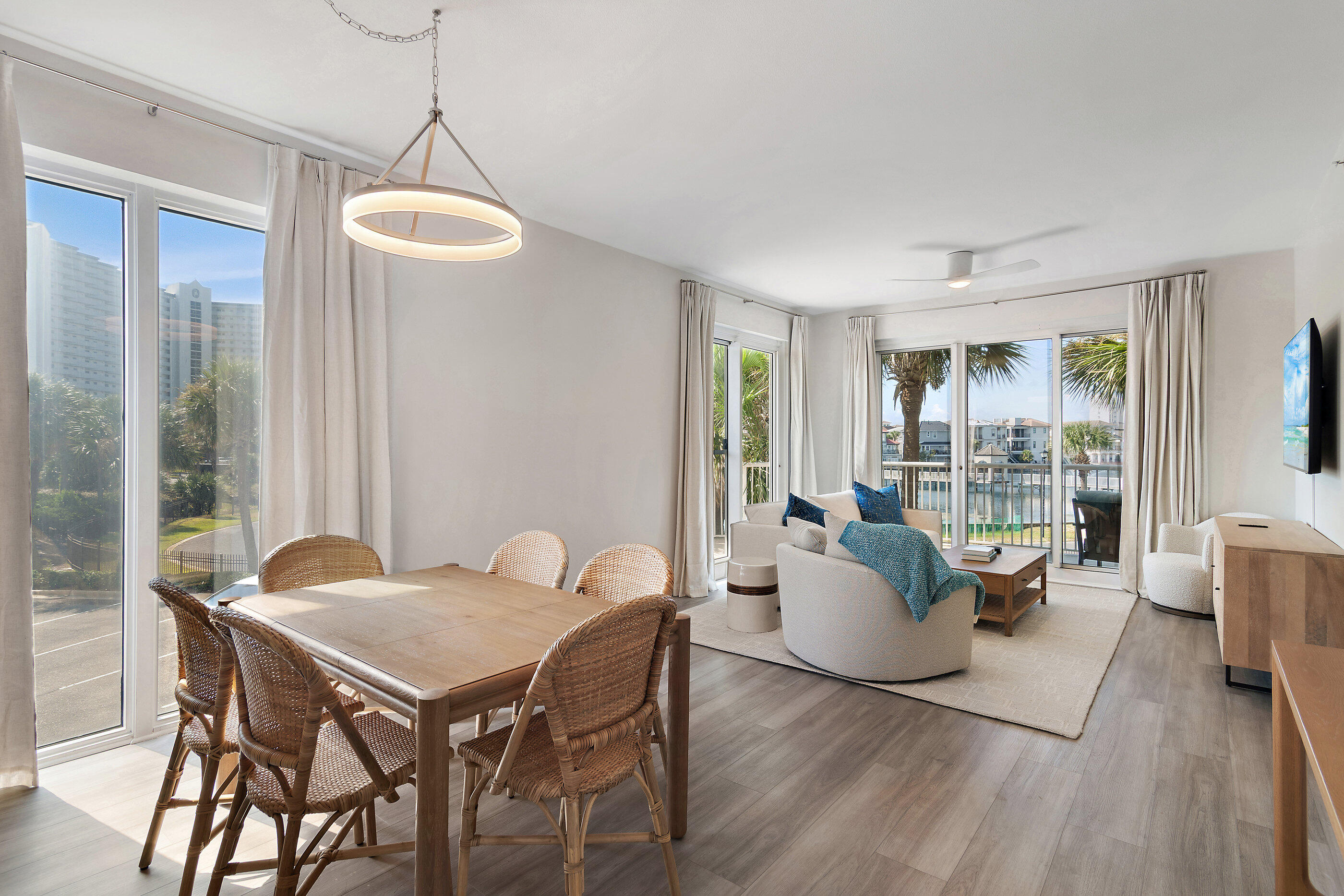 970 Highway 98, Unit 107 Destin, FL 32541 - Photo 9 of 28 a view of a dining room with furniture wooden floor and a chandelier