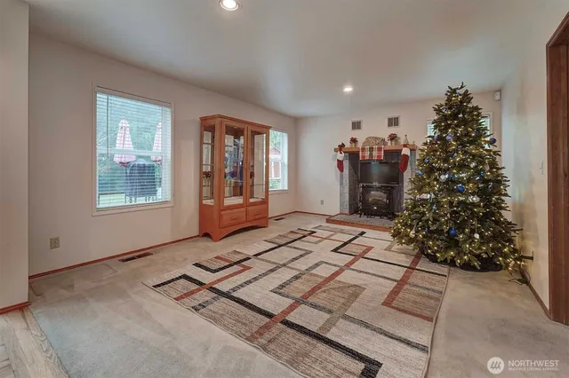 a living room with stainless steel appliances kitchen island granite countertop a refrigerator and cabinets