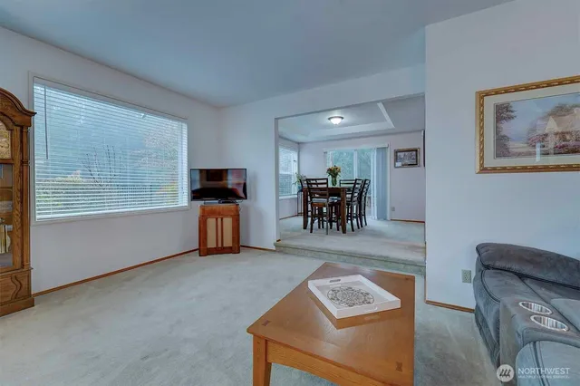 a view of an empty room with furniture and a window