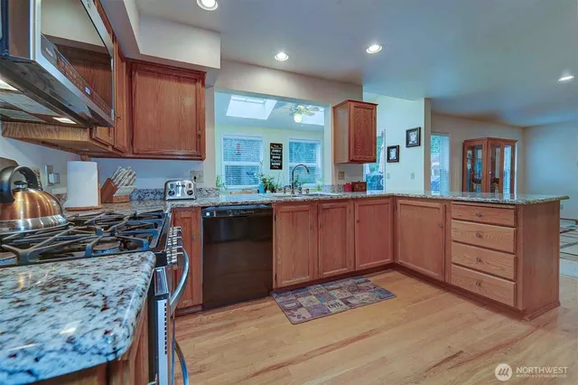 a kitchen with stainless steel appliances granite countertop a sink stove and cabinets