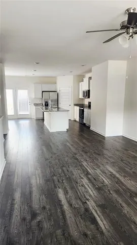a view of a kitchen with furniture and wooden floor
