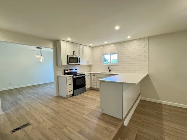 a kitchen with stainless steel appliances granite countertop a sink and a stove top oven