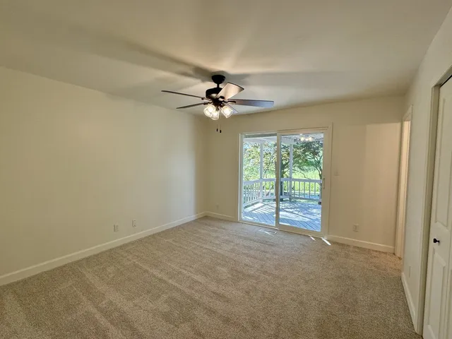 a view of a room with a ceiling fan and a window
