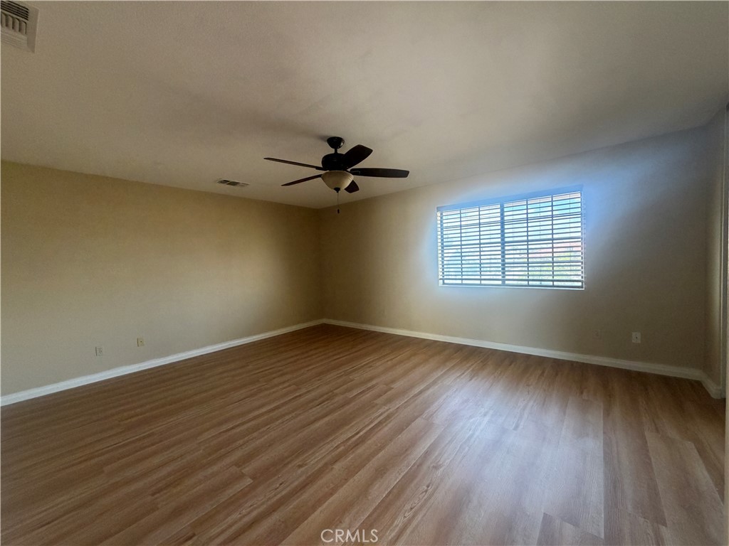 19609 Seneca Road Apple Valley, CA 92307 - Photo 20 of 37 a view of an empty room with wooden floor and a window