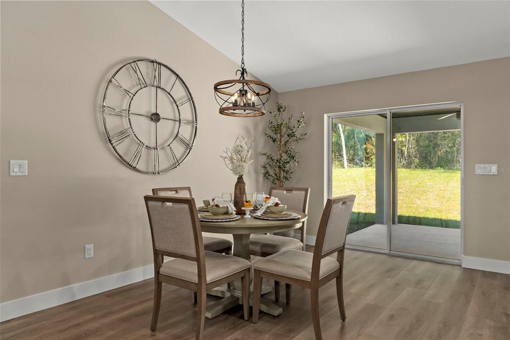 3011 East Griffin Street Inverness, FL 34453 - Photo 18 of 45 a dining room with wooden floor a glass table and chairs