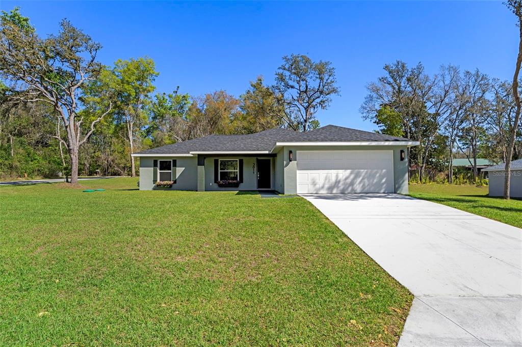 3011 East Griffin Street Inverness, FL 34453 - Photo 2 of 45 a front view of a house with a garden and trees