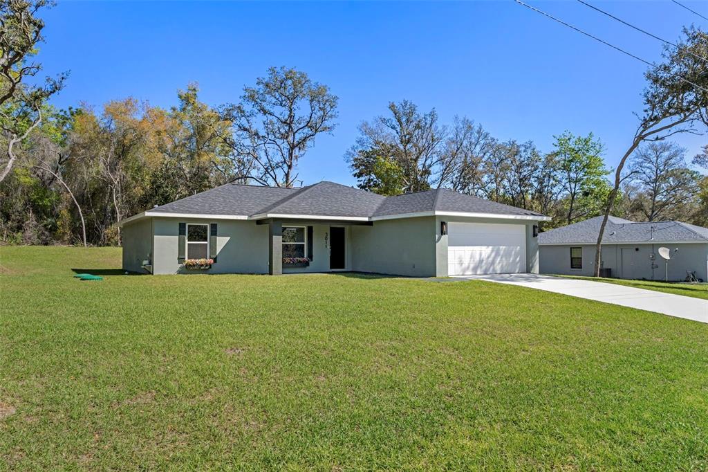 3011 East Griffin Street Inverness, FL 34453 - Photo 9 of 45 a front view of a house with a garden and tree