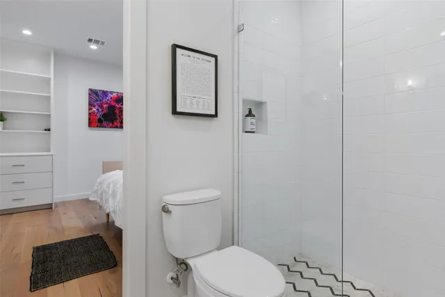 a white toilet sitting next to a bathroom sink and vanity