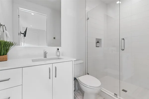 a bathroom with a granite countertop sink a toilet and shower