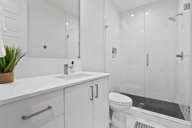 a bathroom with a sink a toilet and shower