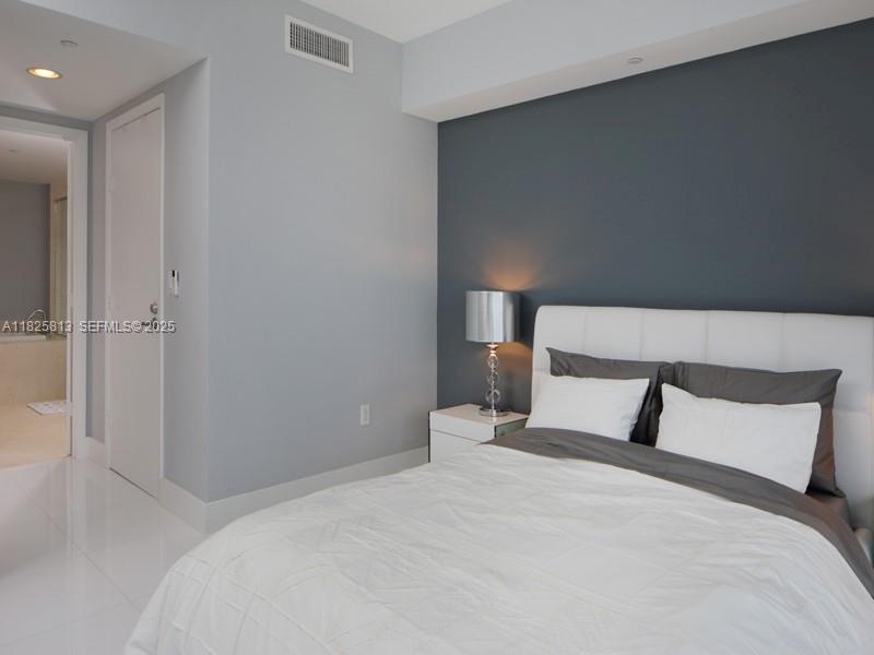 495 Brickell Avenue, Unit 4205 Miami, FL 33131 - Photo 16 of 21 a bedroom with a bed and a night stand