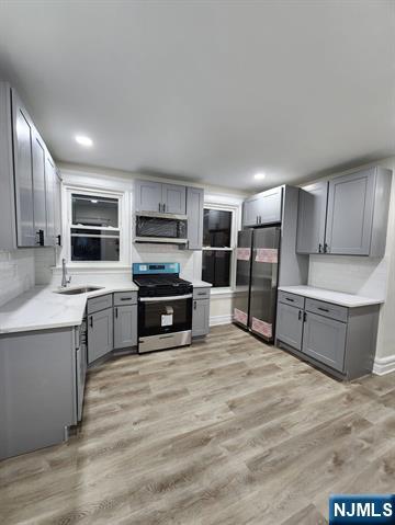a large kitchen with cabinets wooden floor and stainless steel appliances