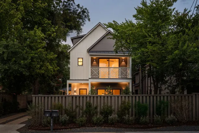 a view of a house with a small yard and wooden fence