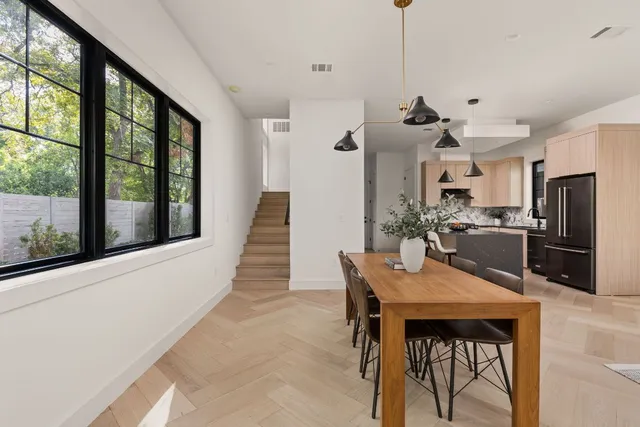 a living room with furniture kitchen view and a chandelier