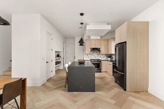 a kitchen with refrigerator a sink and chairs