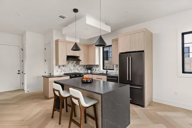 a kitchen with stainless steel appliances granite countertop a sink a stove and a refrigerator