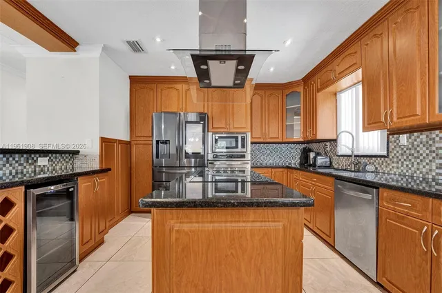 a kitchen with stainless steel appliances granite countertop a sink and a refrigerator
