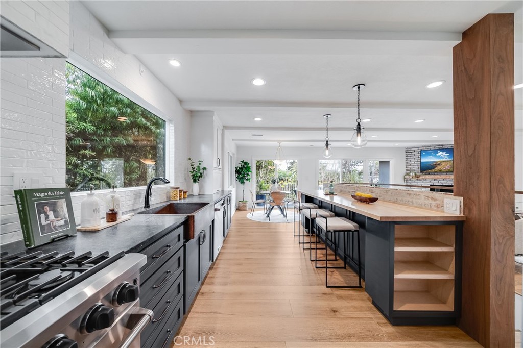 26822 Calle Real Dana Point, CA 92624 - Photo 12 of 41 a open kitchen with stainless steel appliances granite countertop a stove top oven a sink dishwasher and a dining table with garden view
