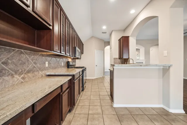 a kitchen with stainless steel appliances granite countertop a sink and cabinets