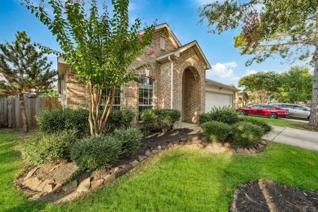 a front view of a house with a yard and potted plants
