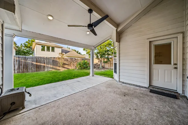 a view of a house with a small yard and a large parking space