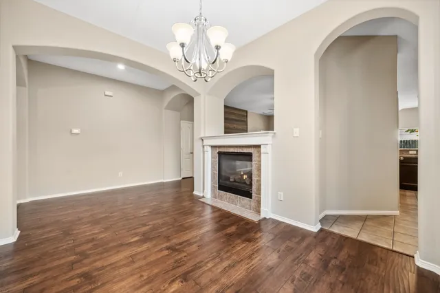 a view of a livingroom with a fireplace wooden floor and a chandelier