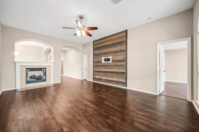 a view of a livingroom with wooden floor and a ceiling fan