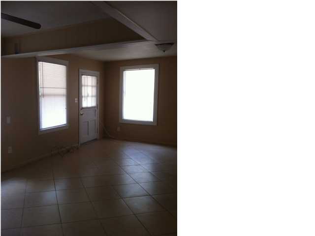 626 Dixie Street Crestview, FL 32536 - Photo 7 of 12 a view of an empty room with wooden floor and a window