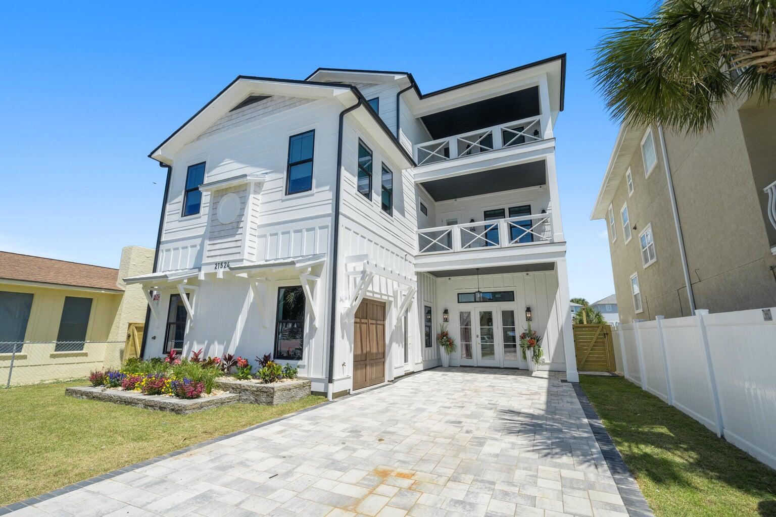 21524 Front Beach Road Panama City Beach, FL 32413 - Photo 3 of 73 a view of a white house with a small yard and plants
