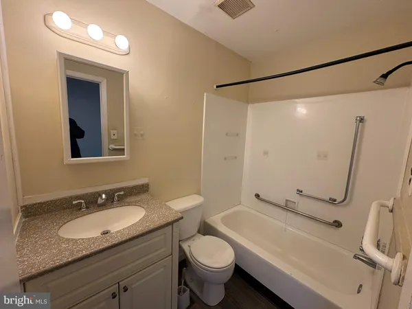 a bathroom with a granite countertop sink toilet and shower