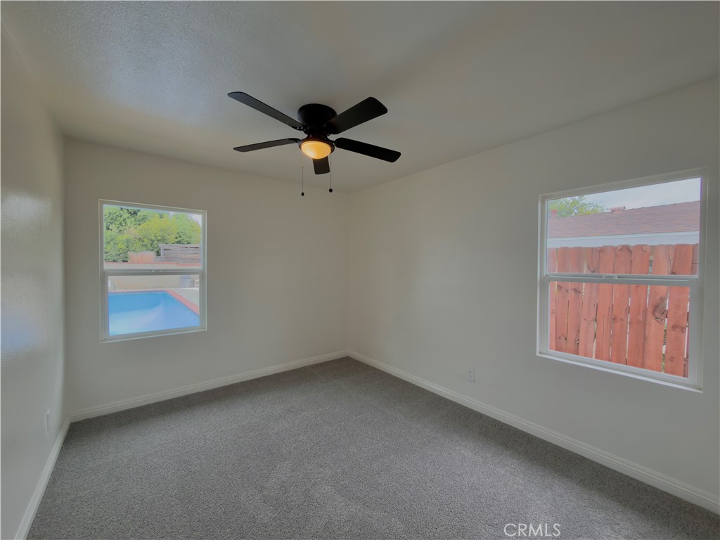 332 East Rosewood Street Rialto, CA 92376 - Photo 16 of 22 an empty room with a window and a fan