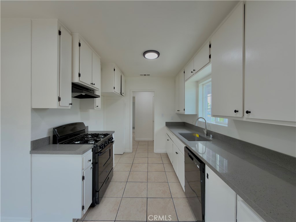 332 East Rosewood Street Rialto, CA 92376 - Photo 7 of 22 a kitchen with granite countertop a sink a stove and cabinets