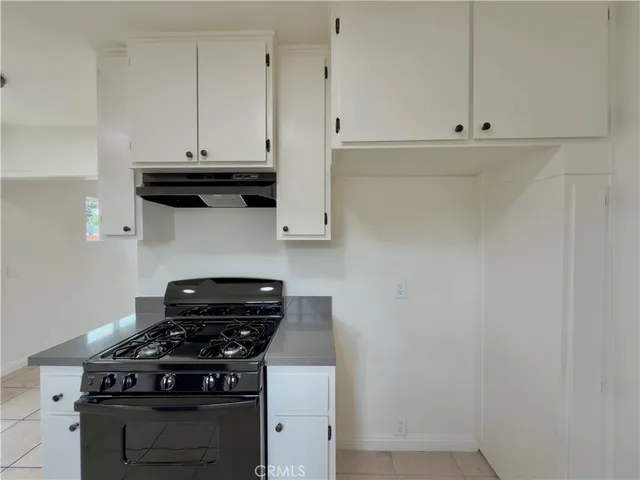 a kitchen with white cabinets and black appliances