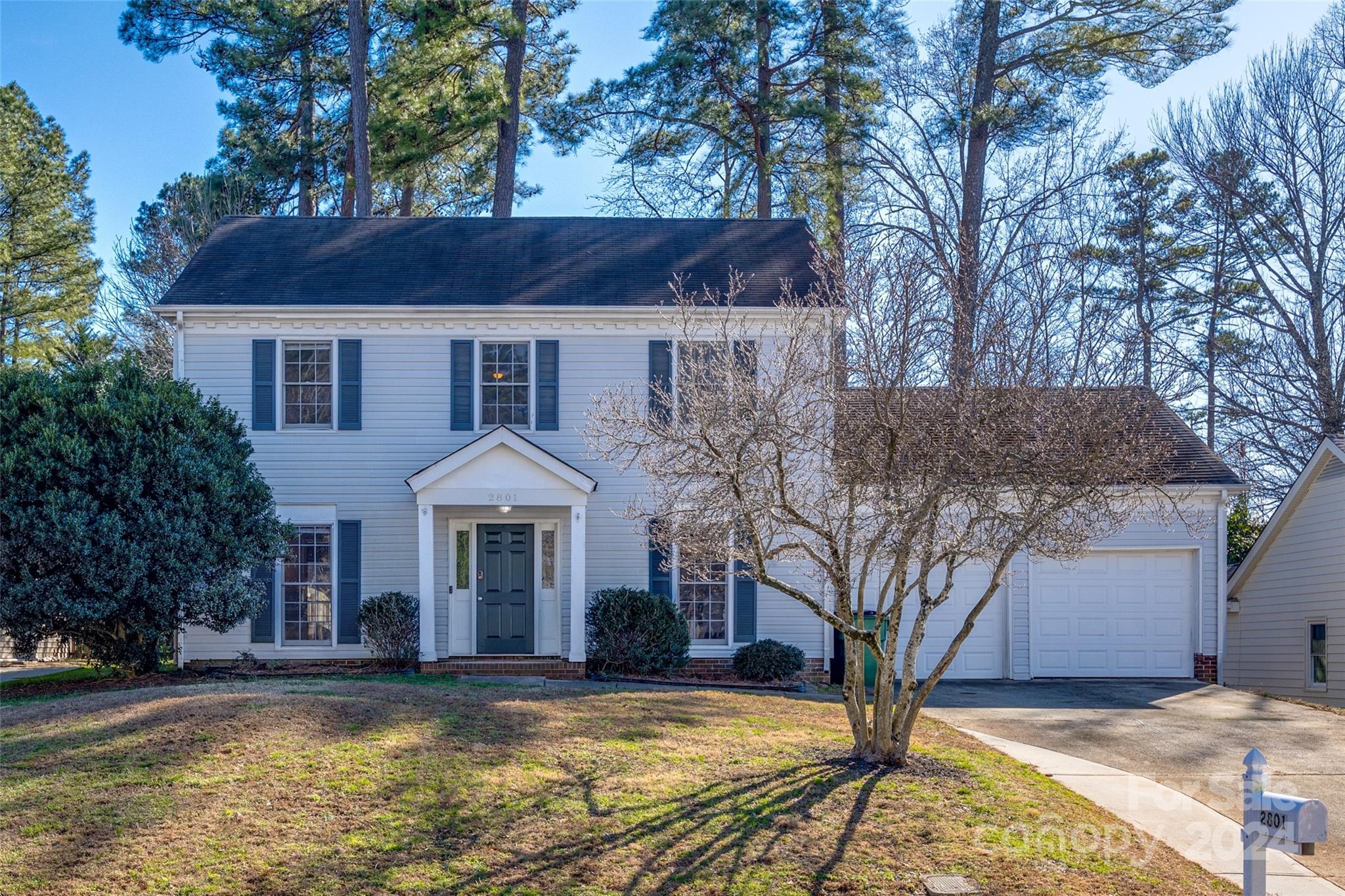 a front view of a house with yard and trees
