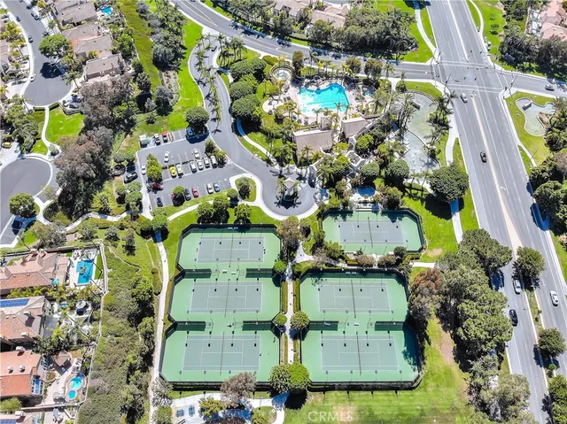 a view of a tennis ground with large trees