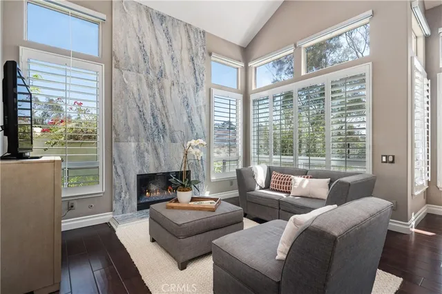 a living room with furniture a fireplace and a large window