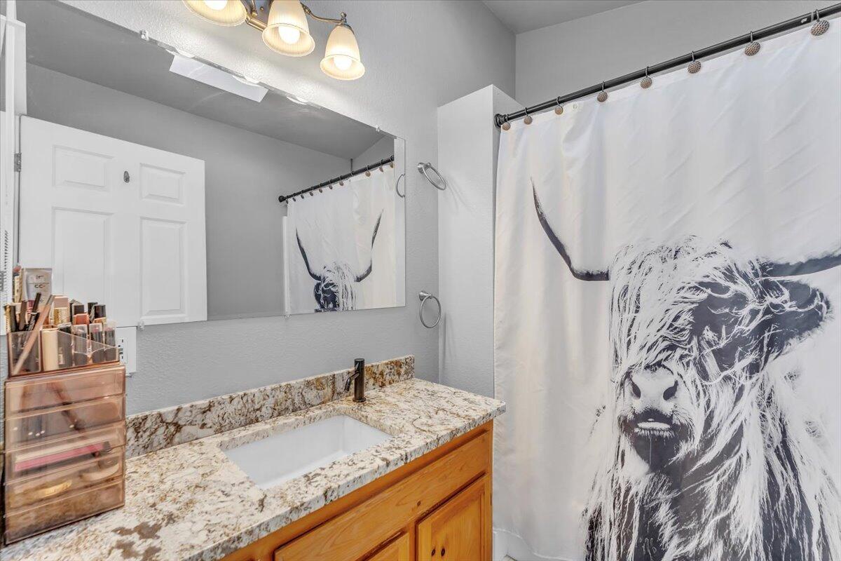 16150 Jellys Ferry Road Red Bluff, CA 96080 - Photo 11 of 37 a bathroom with a granite countertop sink and a mirror