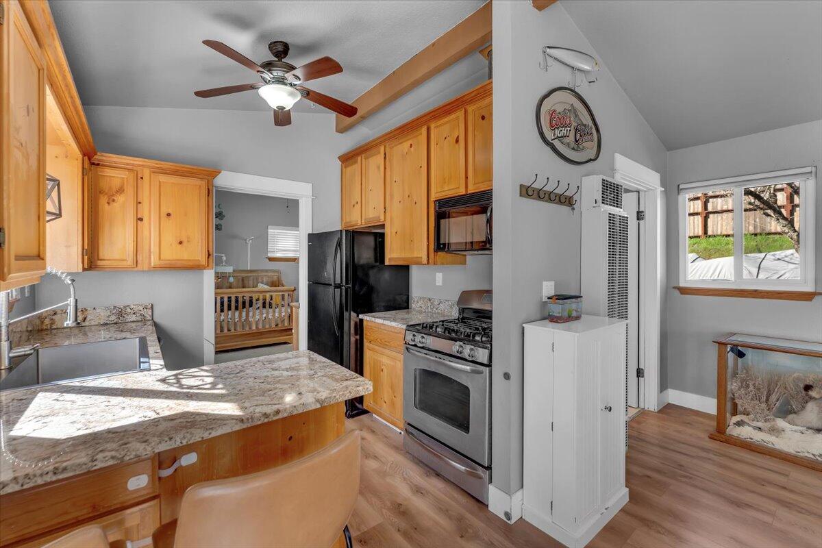 16150 Jellys Ferry Road Red Bluff, CA 96080 - Photo 10 of 37 a kitchen with stainless steel appliances granite countertop a stove a refrigerator a oven with white cabinets and wooden floor