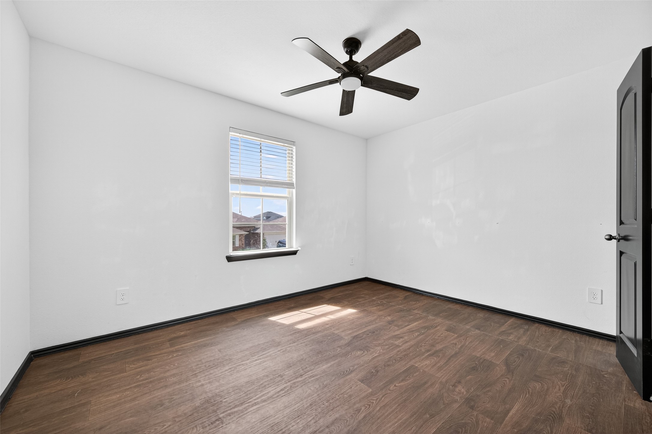21538 Violet Rdg Road Katy, TX 77449 - Photo 29 of 39 an empty room with wooden floor ceiling fan and windows