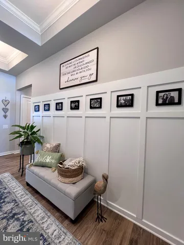 a view of a hallway with wooden floor and cabinet