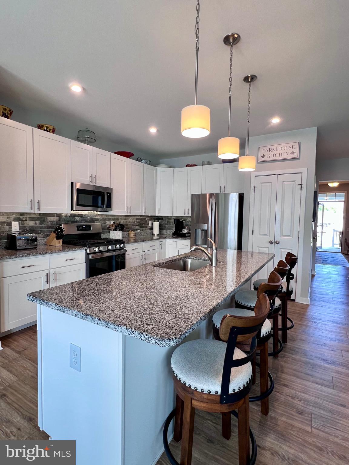 1143 Kayla Lane Townsend, DE 19734 - Photo 41 of 86 a kitchen with stainless steel appliances kitchen island granite countertop a stove a sink a oven a dining table and chairs