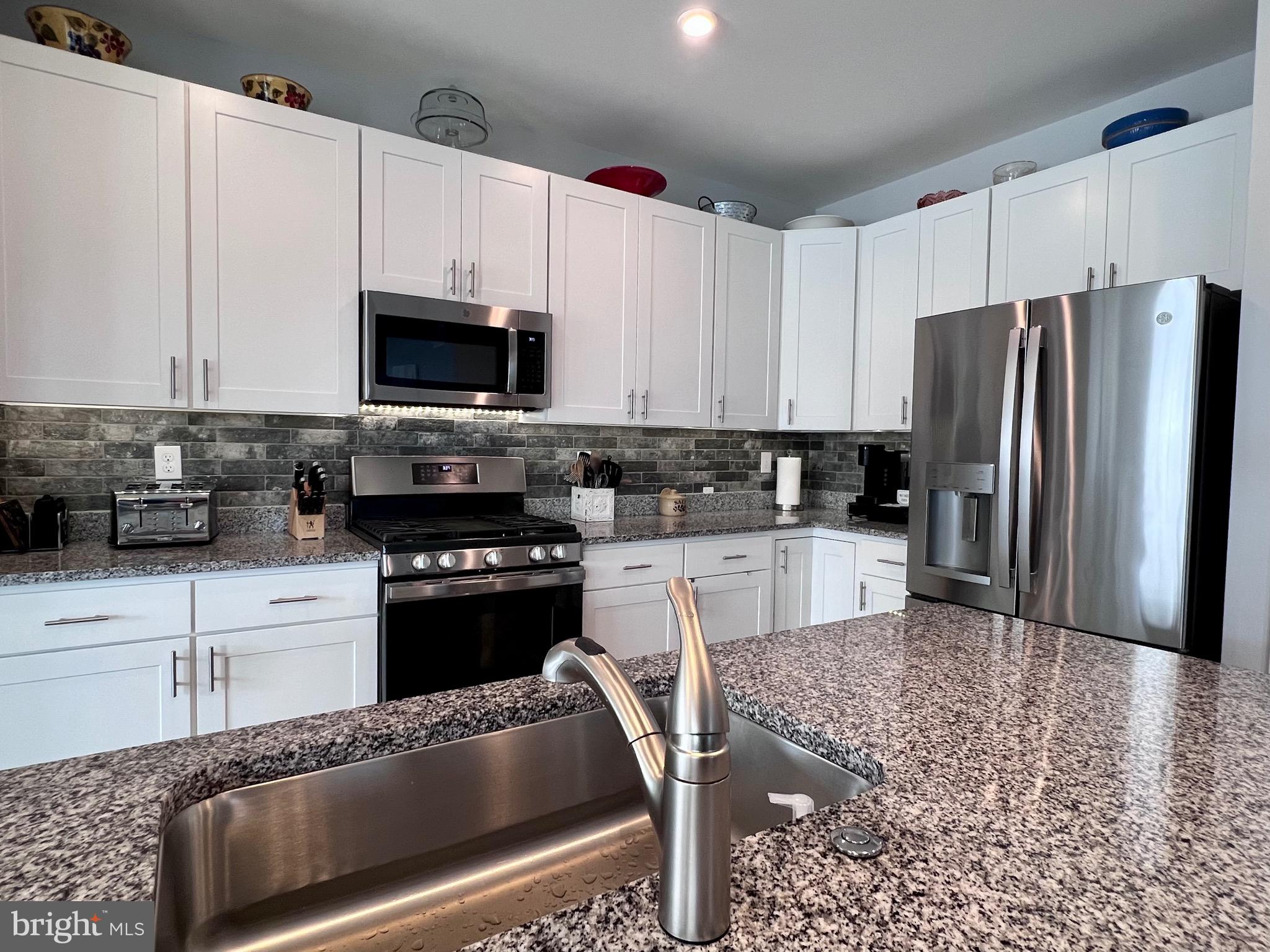 1143 Kayla Lane Townsend, DE 19734 - Photo 44 of 86 a kitchen with granite countertop a refrigerator stove and microwave