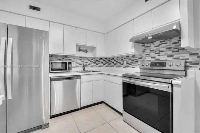 a kitchen with stainless steel appliances white cabinets and a stove