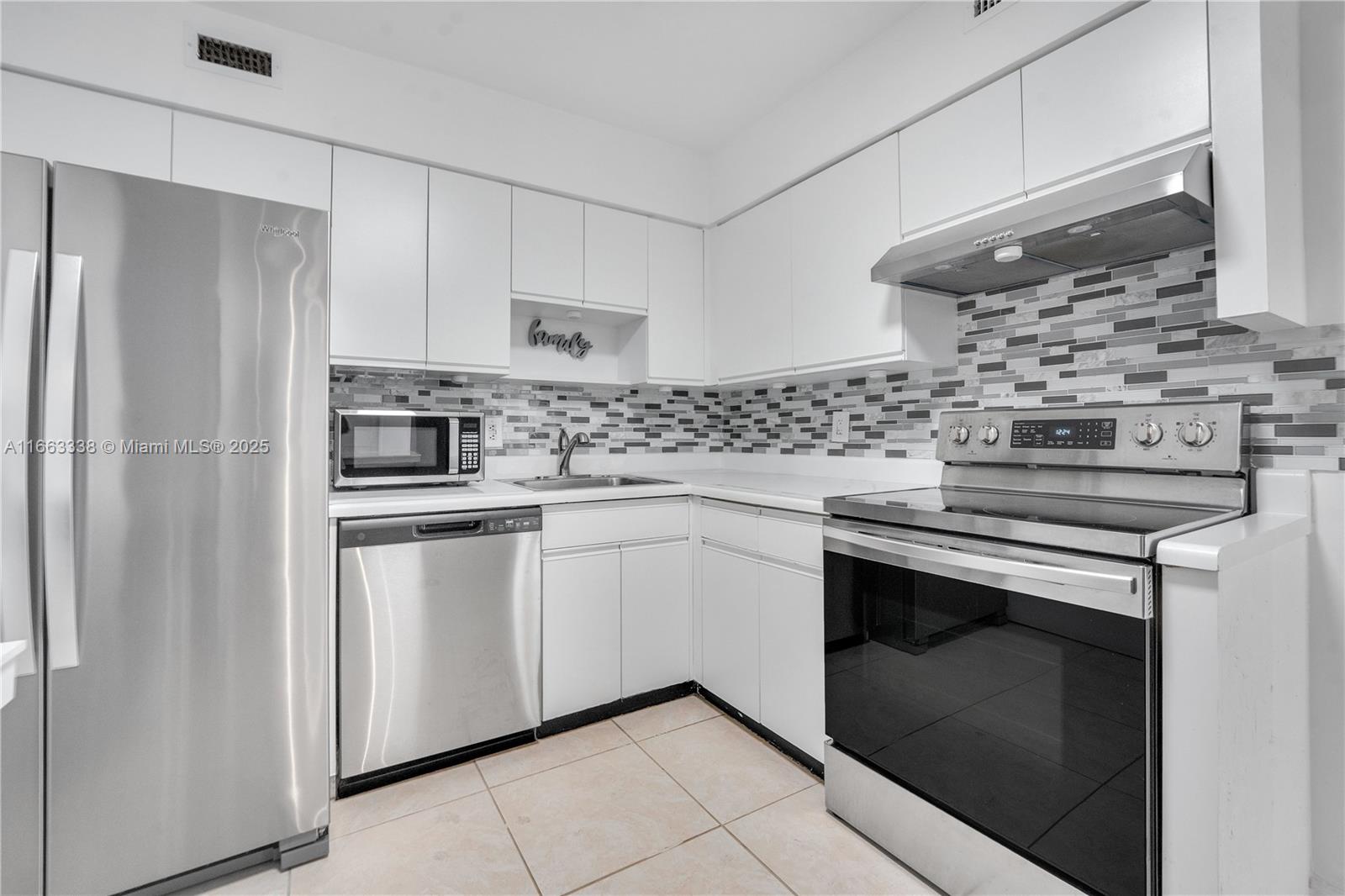 5151 Collins Avenue, Unit 925 Miami Beach, FL 33140 - Photo 11 of 23 a kitchen with stainless steel appliances white cabinets and a stove
