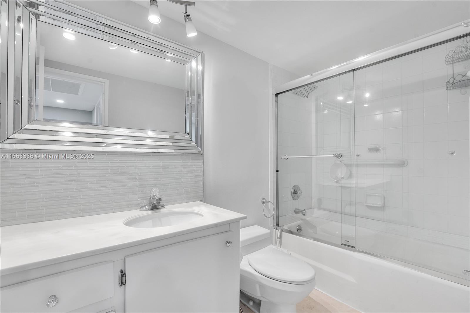 5151 Collins Avenue, Unit 925 Miami Beach, FL 33140 - Photo 18 of 23 a bathroom with a sink a toilet and shower