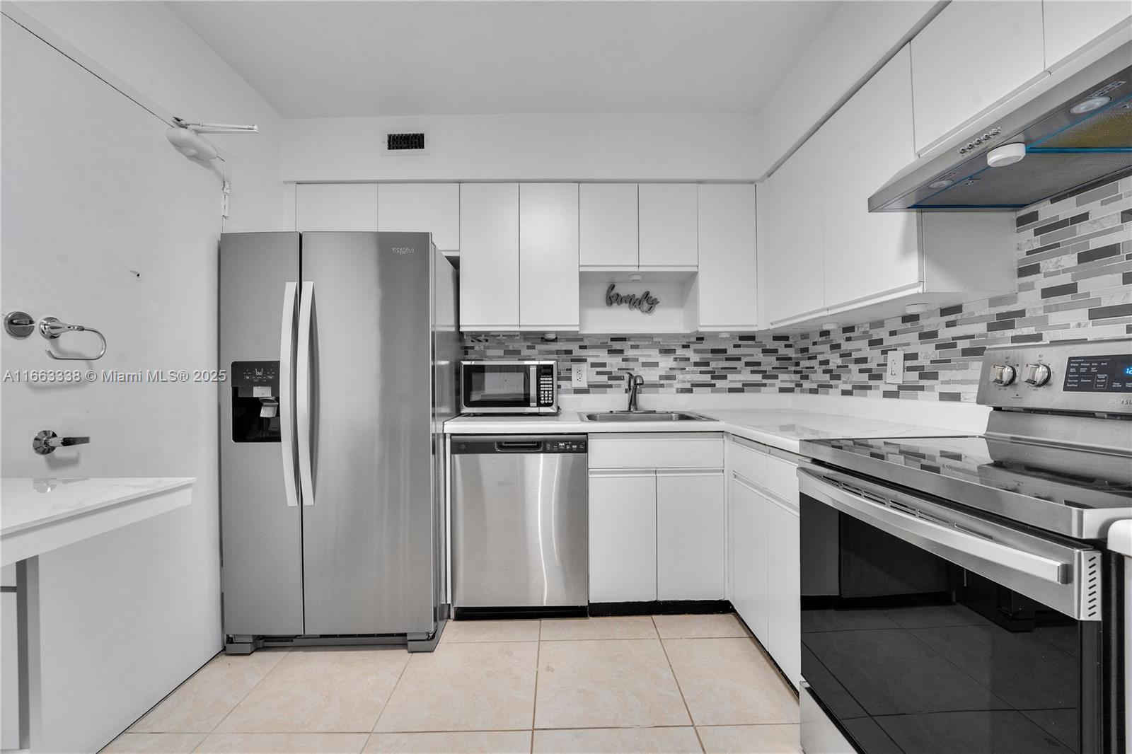 5151 Collins Avenue, Unit 925 Miami Beach, FL 33140 - Photo 10 of 23 a kitchen with stainless steel appliances a stove sink and refrigerator