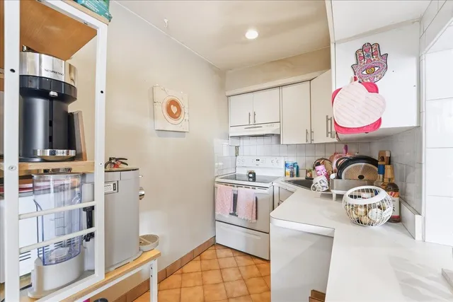 a view of kitchen and sink with stove and cabinets