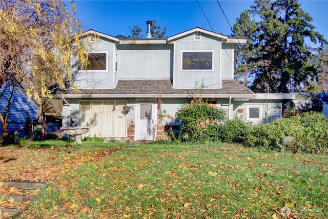 a view of a house with a yard and sitting area