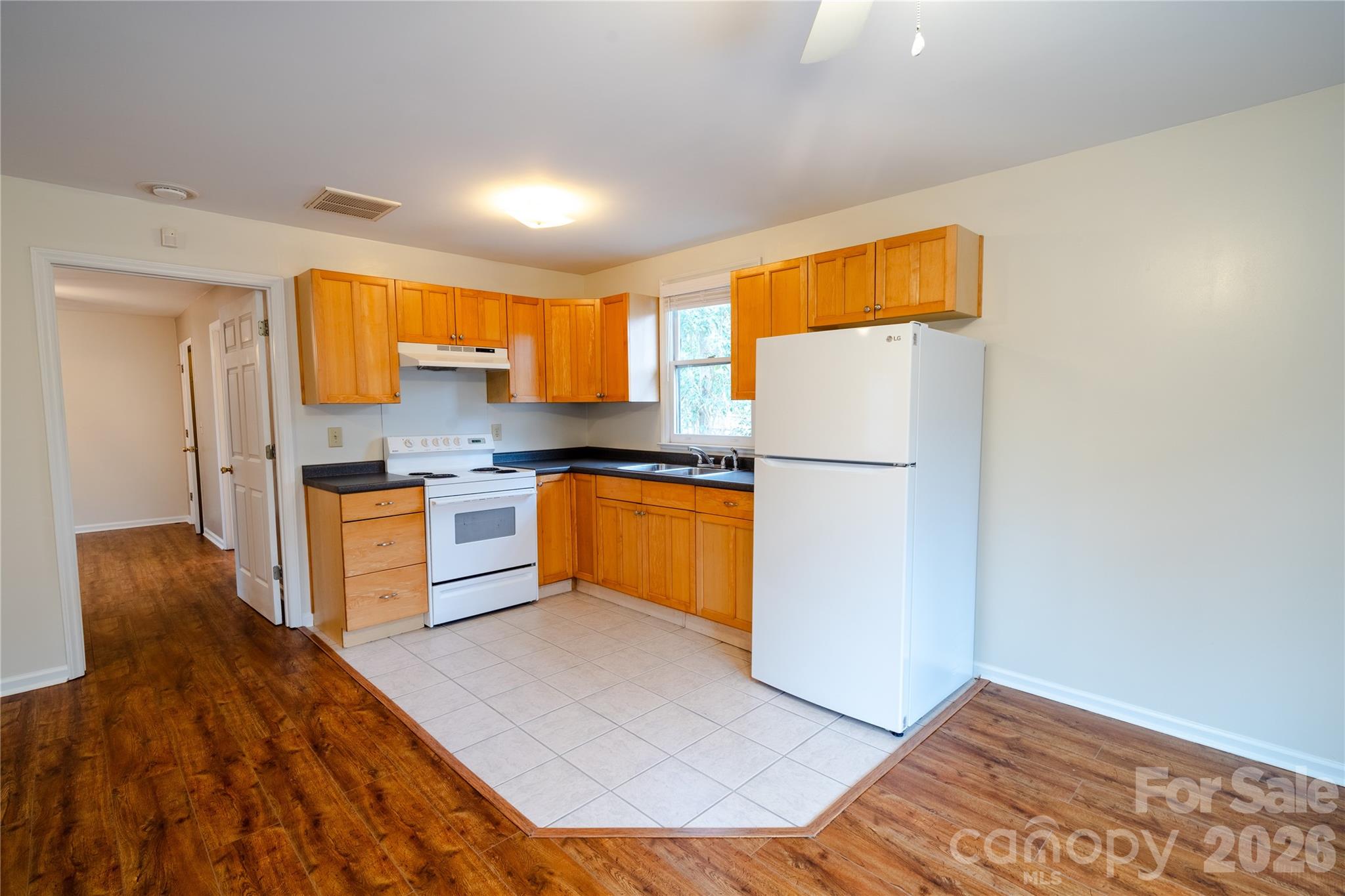 5315 Ruth Drive Charlotte, NC 28215 - Photo 5 of 38 a kitchen with granite countertop a refrigerator and a stove top oven